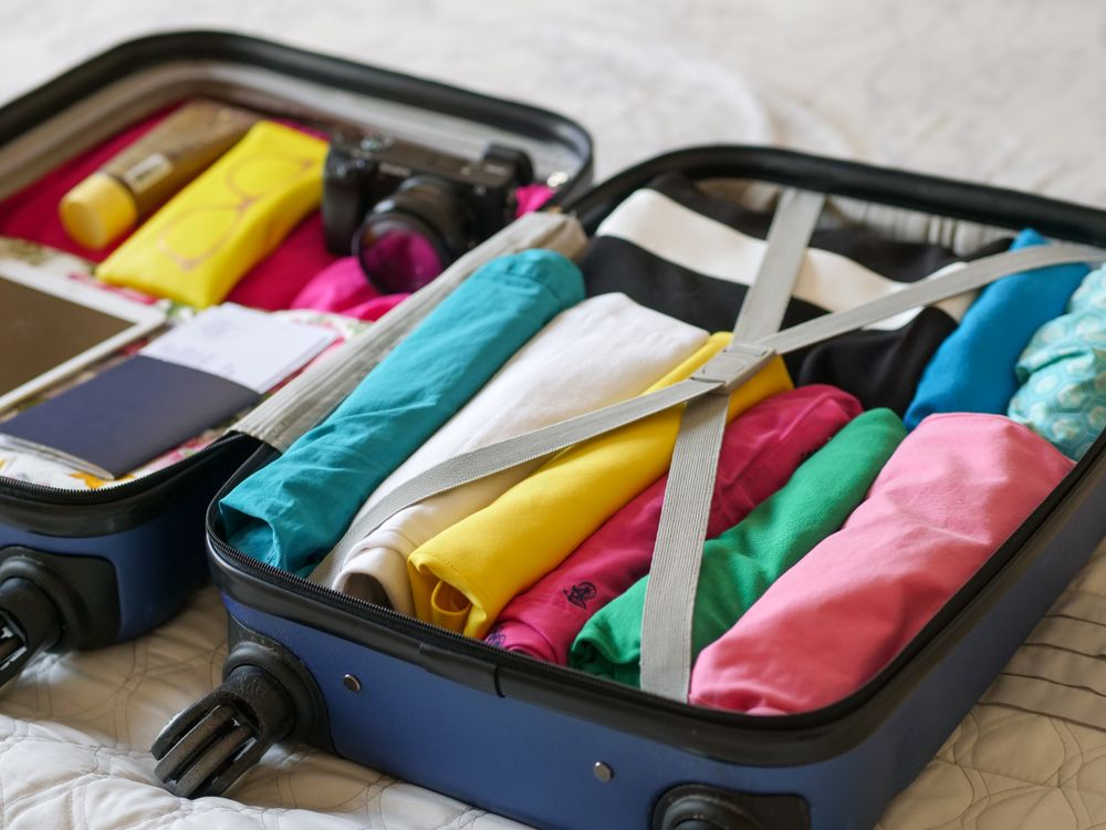 An open suitcase neatly packed with folded clothes