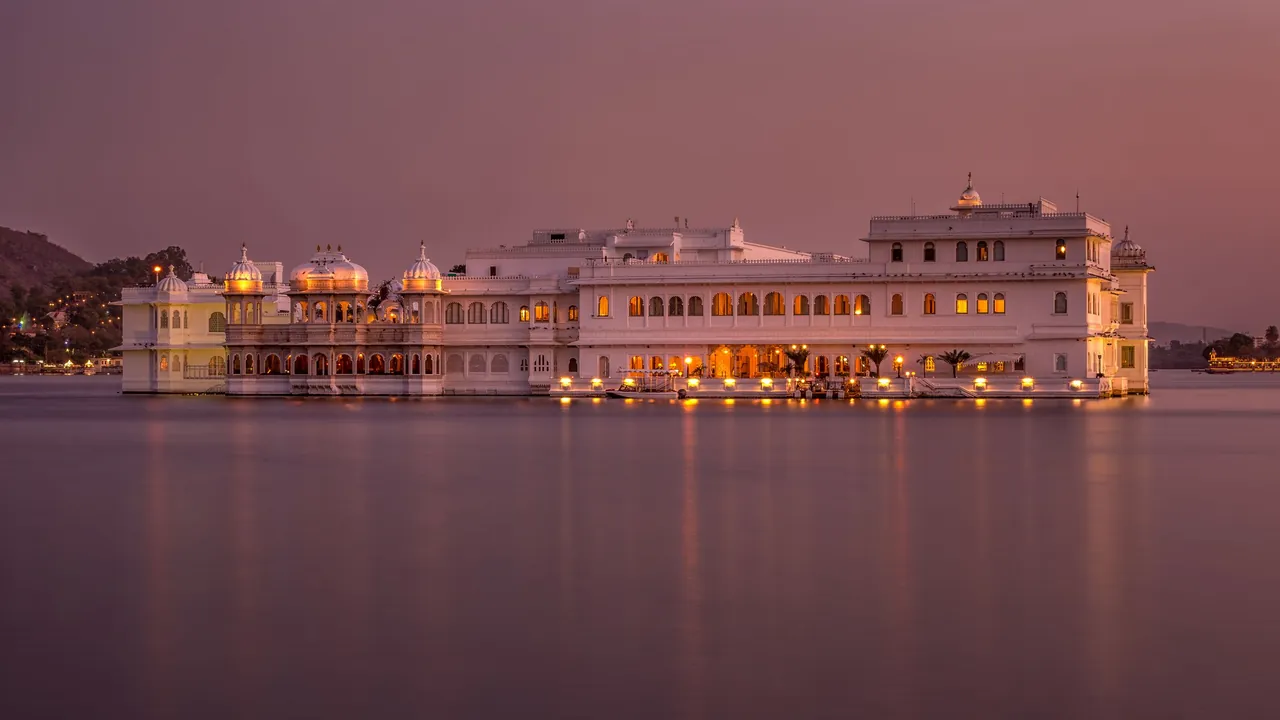 Taj Lake Palace on Lake Pichola in Udaipur lit up at twilight