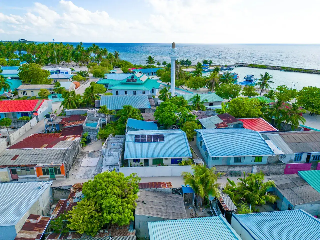 Aerial view of an inhabited local island in the Maldives with houses and palm trees