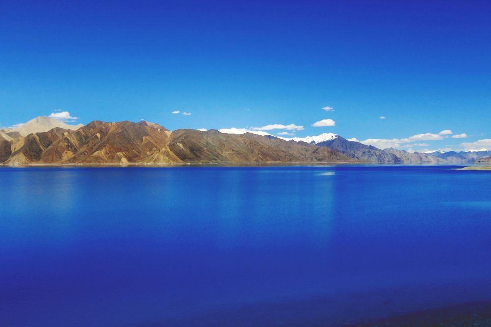 The blue waters of Pangong Lake framed by mountains in Ladakh