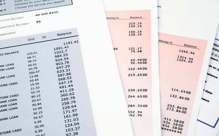 Financial documents, charts and a calculator being reviewed while preparing a visa application