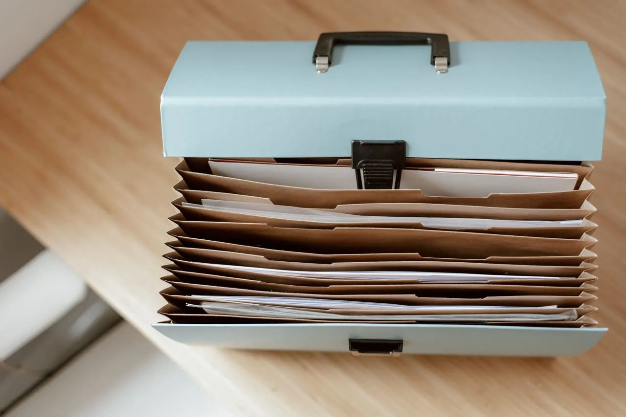 Neatly organised folders of supporting paperwork in a document case on a desk