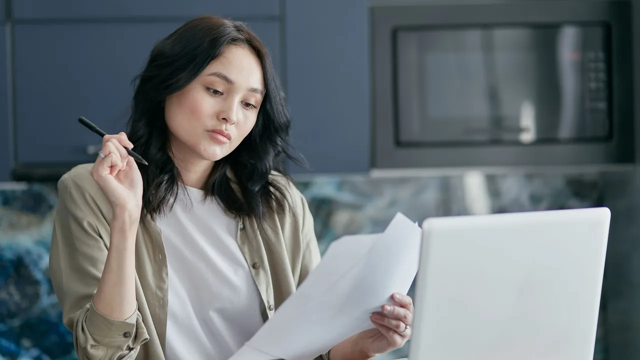 Applicant cross-checking visa application papers at a desk before submitting